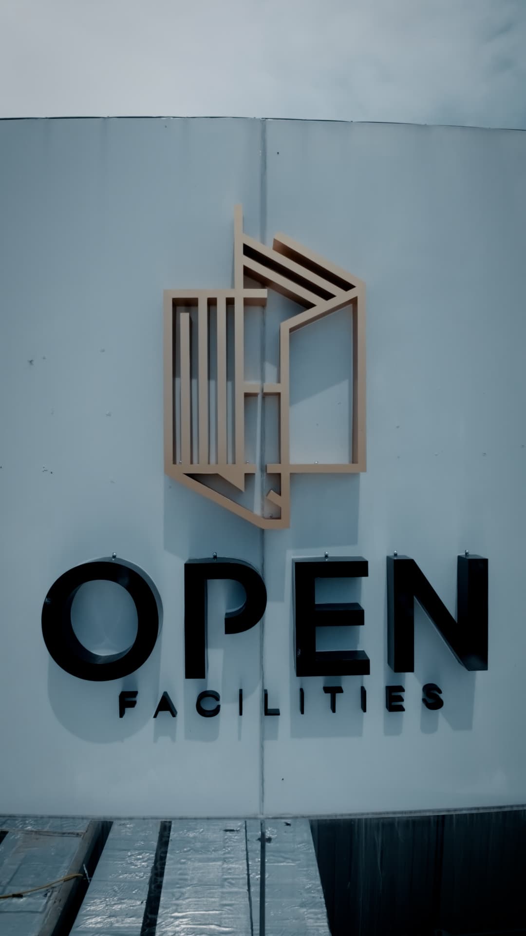 Fachada da sede da Open Facilities, com identidade visual da empresa em destaque